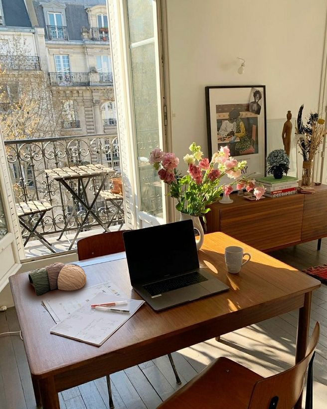 Studio Echo Form sunlit workspace with laptop, flowers, wall planters and open balcony