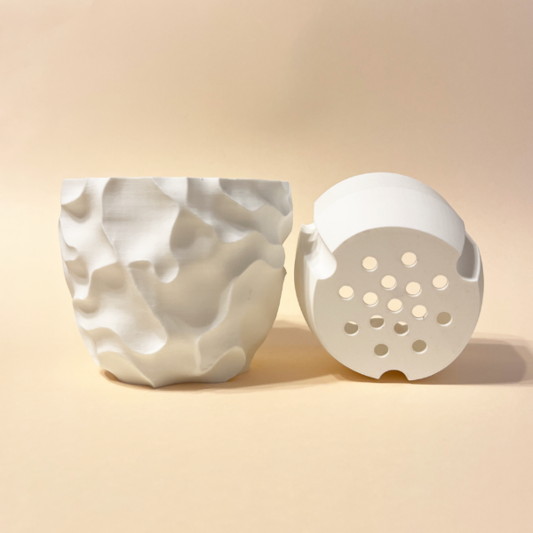 White 3D-printed planter with sculptural surface texture shown alongside its removable drainage insert