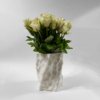 White 3D-printed sculptural vase with a textured, dimpled surface, filled with fresh white roses
