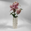 White 3D-printed Amphitrite vase with a sculptural, dimpled texture, holding a bouquet of pink lilies