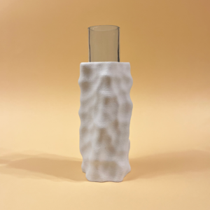 Tall glass vase partially encased in a white 3D-printed sculptural vase with a textured surface