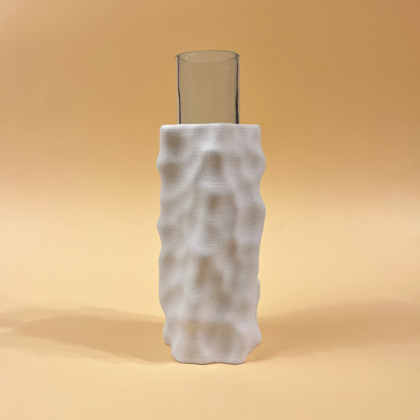 Tall glass vase partially encased in a white 3D-printed sculptural vase with a textured surface
