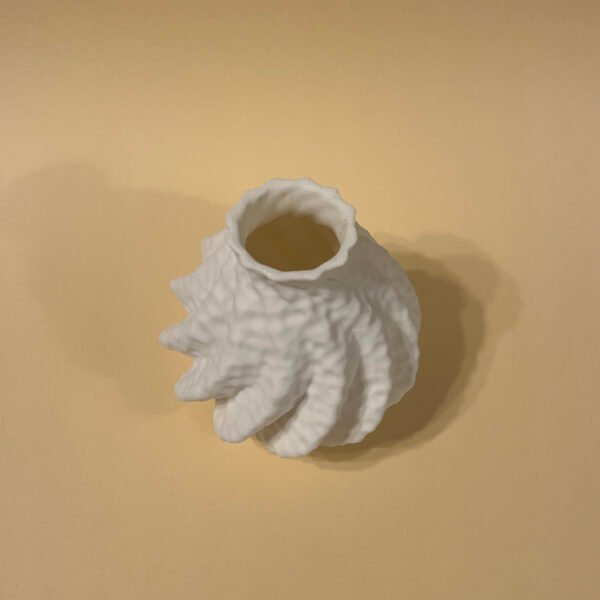 Top-down view of Astraeus vase – soft sculptural form in peachy background
